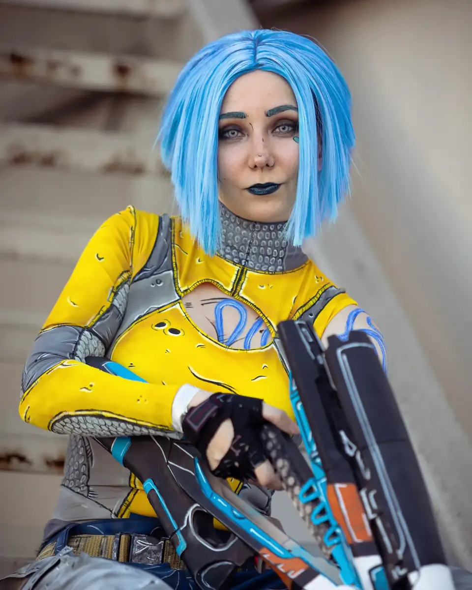 Kally cosplaying in a blue wig and yellow bodysuit