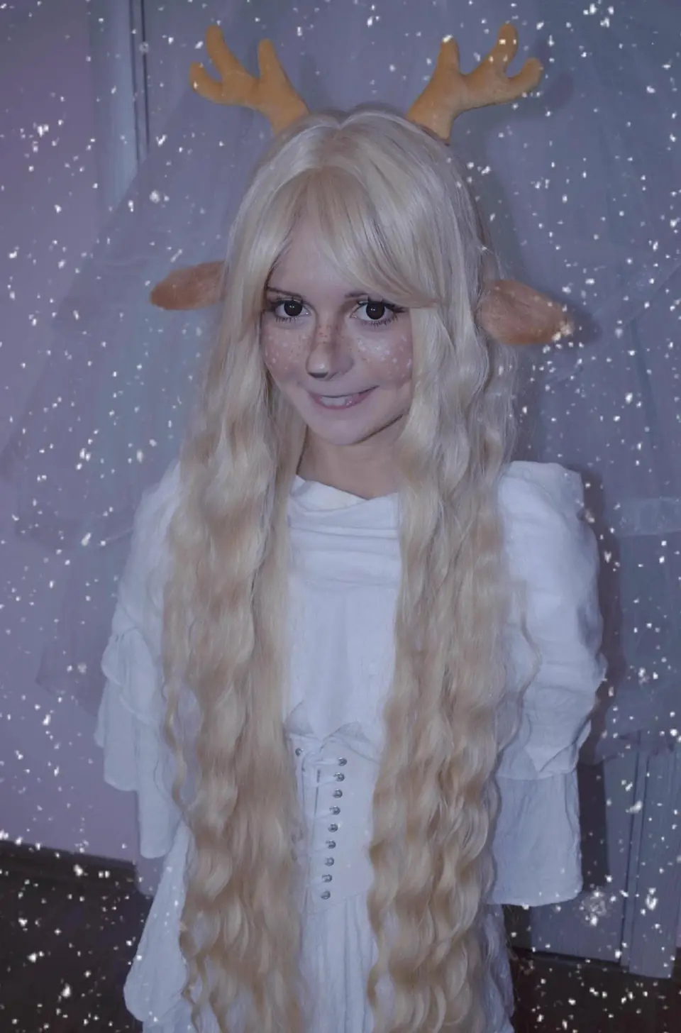 Moni in a white costume with deer antlers and painted freckles